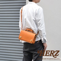 職人手作皮革經典兩用雙扣迷你單肩包，採用天然皮革，經典的駝色，配有可調節的肩帶和頂部提把，兩個金色旋轉鎖扣設計，適合日常搭配。