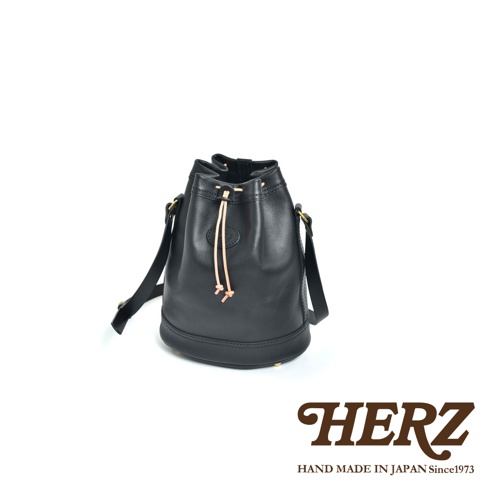 職人手作皮革束口單肩包，黑色，採用圓筒狀皮革設計，束口處有淺色皮革細繩，可斜背或單肩背。