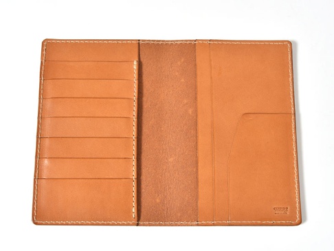 職人手作皮革多用途收納長夾，淺棕色牛皮材質，內有六個卡槽，一個長形夾層，以及右側兩個不同深淺的收納夾層。縫線為白色，整體風格簡約。