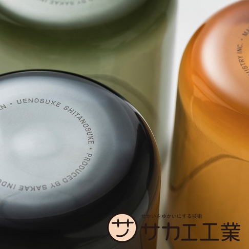 SAKAE UENOSUKE SHITANOSUKE 二合一可蓋水杯，底部印有「PRODUCED BY SAKAE INDUSTRY INC.」，搭配品牌標誌和日文口號。