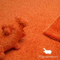 橘色竹棉混紡厚感長毛巾，觸感柔軟，毛圈細緻，呈現豐富的紋理。一角捲起，另一角有可愛的河馬造型裝飾和品牌Logo。