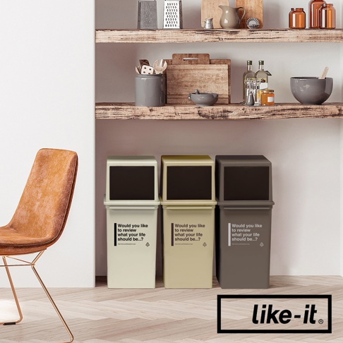 三個 CAFE STYLE 前開式矮版可疊垃圾桶，分別為淺米色、淺黃色和深灰色，帶有黑色前開式面板和印有英文文字的白色標籤，放置於木質層架下方。