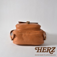 職人手作皮革迷你後背包，採用溫暖的棕褐色皮革，設計立體，配有金屬扣環和可調節的皮革肩帶。