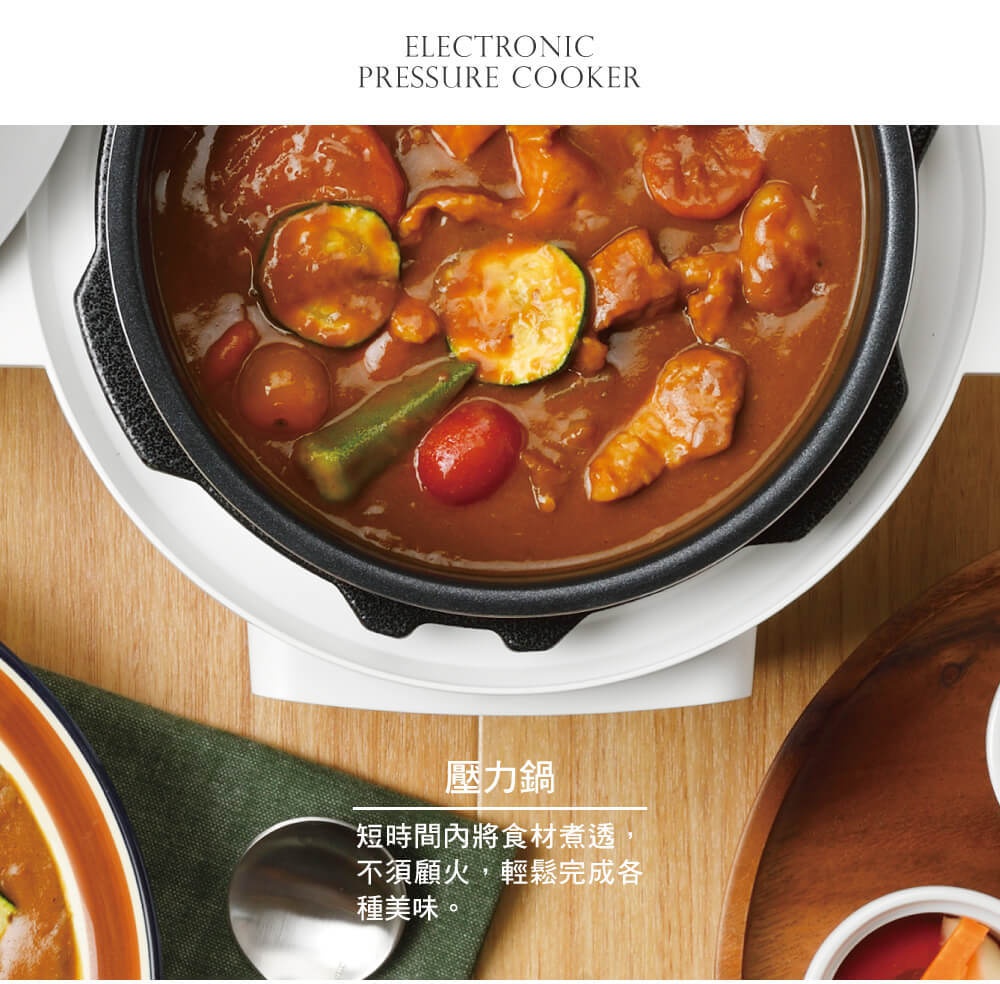 電子壓力鍋 PC-MA2-W 內盛滿香濃咖哩，可見燉煮軟爛的肉塊、櫛瓜片、小番茄及秋葵，鍋身為黑色，外圍白色底座。