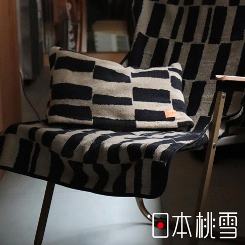 日本桃雪品牌的戶外格紋棉柔2WAY連帽浴巾，上面有一個小小的品牌標籤，浴巾和枕頭都覆蓋著黑白相間的條紋圖案。