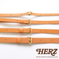 四條淺棕色皮革製成的肩背帶，每條皆配有金色金屬扣環及調節孔，下方有HERZ品牌標誌與手工製作於日本的字樣。