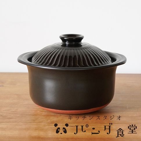 Kitchen Studio Panda食堂萬古燒職人炊飯土鍋，黑色帶有壓紋的鍋蓋，下方是素色黑色鍋身，底部則為橘紅色。