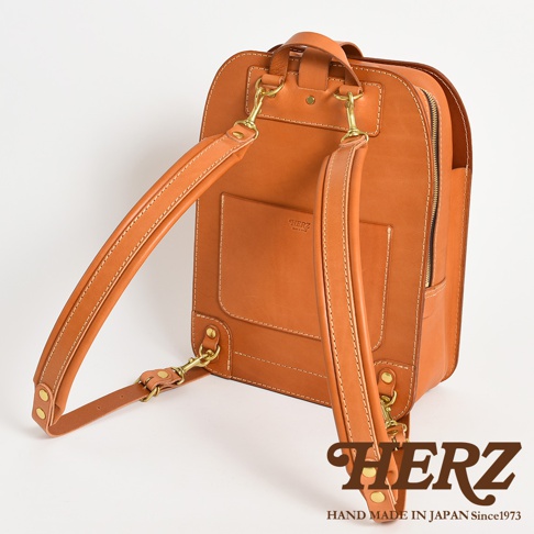 職人手作皮革商務休閒兩用後背包 R-36，展示為經典棕色，採用光滑皮革材質，配有可調節肩帶、黃銅金屬扣件和拉鍊。