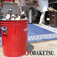 紅色的 OBAKETSU 垃圾桶裡裝滿了啤酒瓶，旁邊是藍色印花地毯和兩個人。