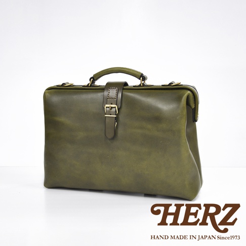 職人手作皮革軟式杜勒斯包，深綠色，附有金屬扣帶和提把，展現皮革自然紋理。