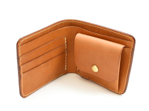 職人手作皮革經典掀蓋扣式雙折短夾，展示內側，淺棕色光滑皮革，有四個卡槽及一個附黃銅按鈕的零錢袋。
