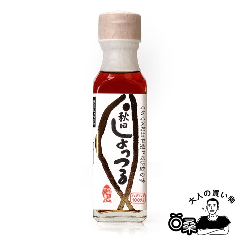 秋田魚露130ml，玻璃瓶裝，內含琥珀色液體。瓶身有白色標籤，印有黑色日文書法字體，右側有日文說明文字。瓶蓋為淺棕色，由紙質材料包裹。