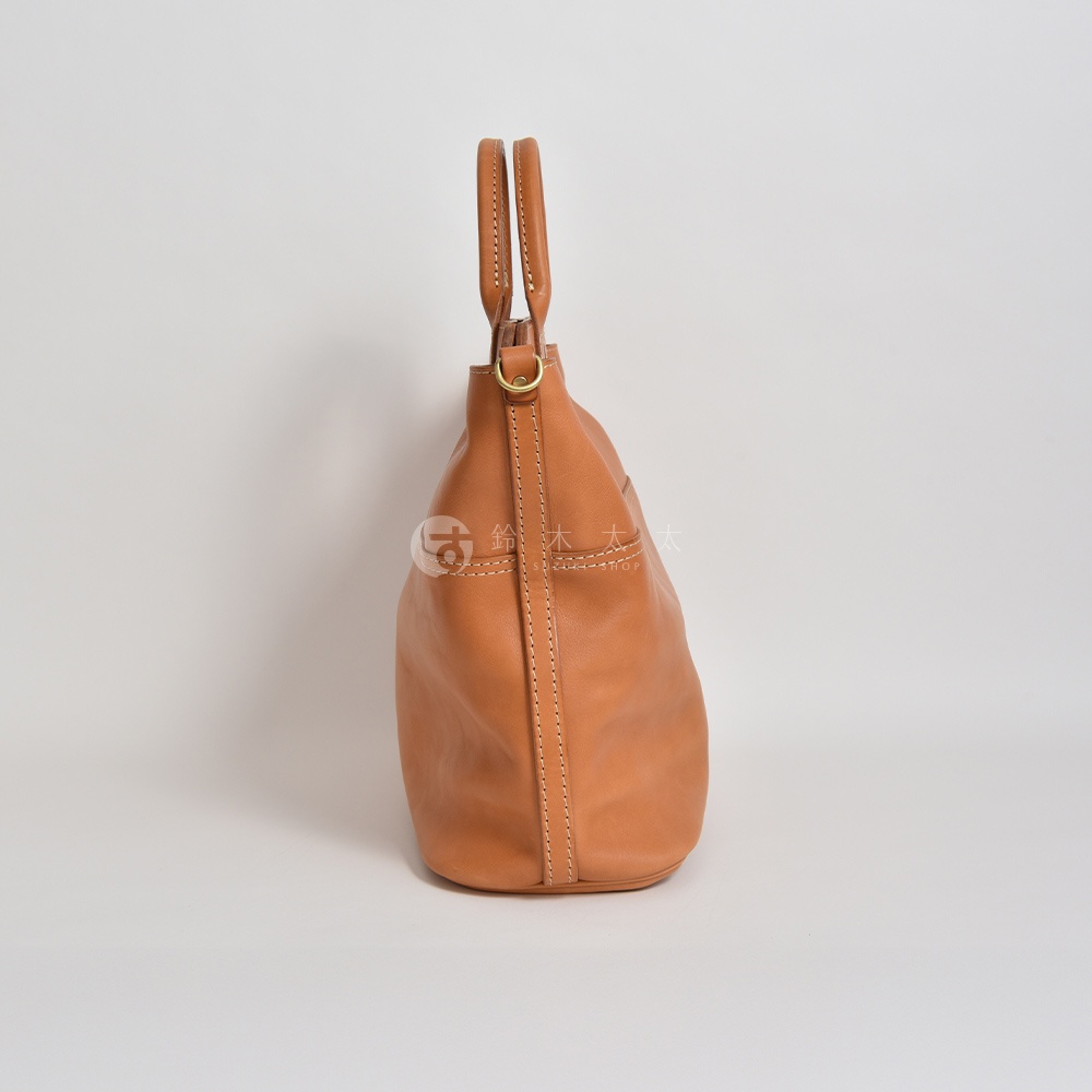 職人手作皮革大容量兩用托特包 T-8，呈現自然棕色，材質為柔軟皮革，包身線條流暢，配有雙提把及金屬環扣，適合日常攜帶。