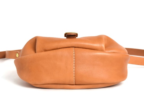 職人手作皮革休閒旅行馬鞍包 (CK-20)，淺棕色皮革，圓潤飽滿的馬鞍造型，搭配金屬扣環，側邊縫線清晰，簡潔實用。