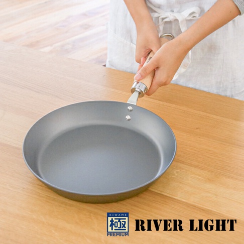 一手持著木柄，露出銀色金屬連結處的 28 公分灰色平底鍋。鍋身為圓形，鍋緣略微向外擴展。