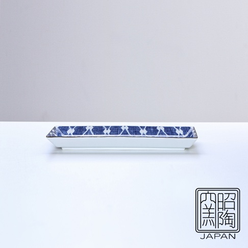 長條形白色陶瓷烤物盤，盤緣飾有藍色菱形網紋，盤邊緣有金色線條點綴，盤底有「照燒 陶瓷 JAPAN」方形黑白印章。
