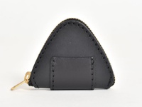 黑色皮革製成的三角形零錢包，帶有金色拉鍊和手工縫線。側面有一個較小的黑色皮革裝飾片。