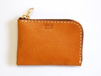 職人手作L型拉鍊軟皮卡片收納夾，呈現溫潤的焦糖棕色，皮革表面帶有自然紋理，搭配同色系縫線和金色拉鍊頭，簡潔實用。