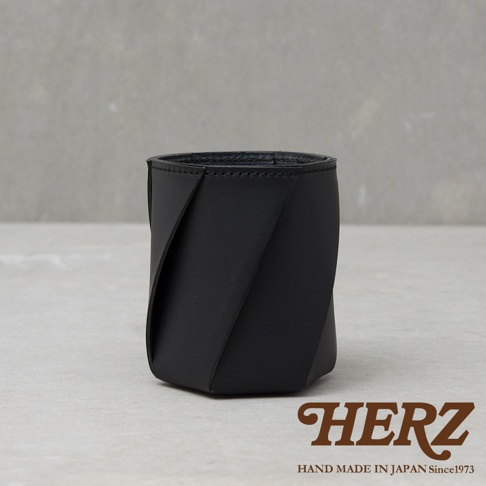 黑色皮革製成的職人手作Organ六角收納筆筒，具有獨特的摺疊設計，展現皮革的紋理與質感。