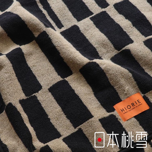 日本桃雪品牌SOLU戶外格紋棉柔2WAY連帽浴巾，標籤上印有HIORIE TOWEL FACTORY IN JAPAN字樣。