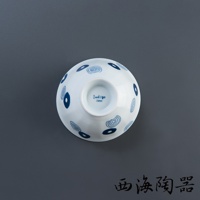 白色陶瓷飯碗，碗身飾有藍色圓形與漩渦紋飾，碗底印有「Indigo Japan」字樣。