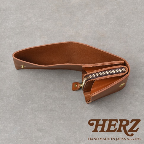 由日本職人品牌HERZ手工打造的Organ系列迷你短夾，以義大利Minerva Liscio皮革製作，棕色皮革呈現自然紋理，採簡約的長幅單片折疊設計，內部配有帶拉鍊的寬敞零錢袋及多功能夾層，體現細膩的手作工藝。
