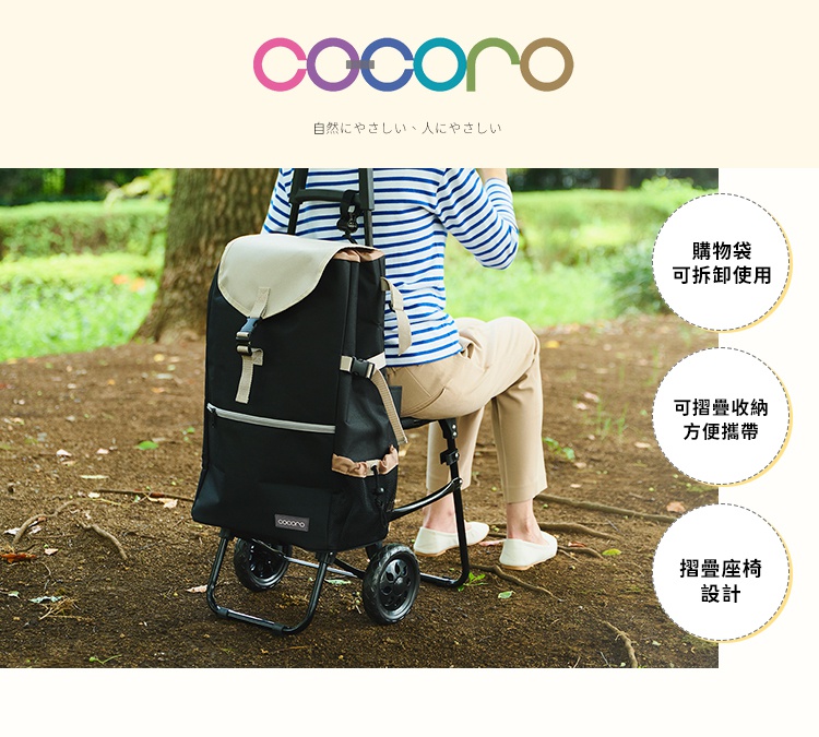 一位穿著條紋上衣的女性坐在戶外的一台黑色COCORO購物車上，這款購物車具備摺疊座椅設計，購物袋可拆卸使用且能摺疊收納，方便攜帶。