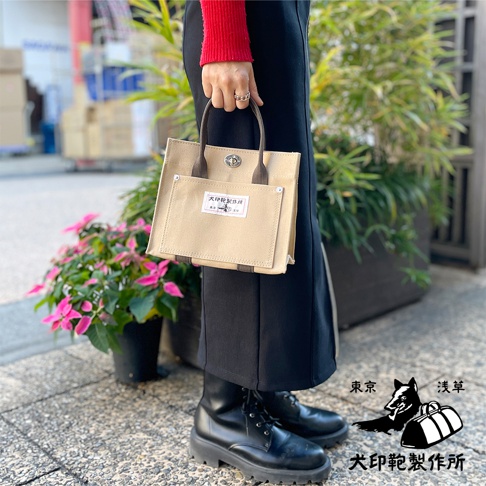 犬印純棉帆布迷你托特包，米白色帆布材質，配有棕色皮革提把，正面有外袋和品牌標籤。