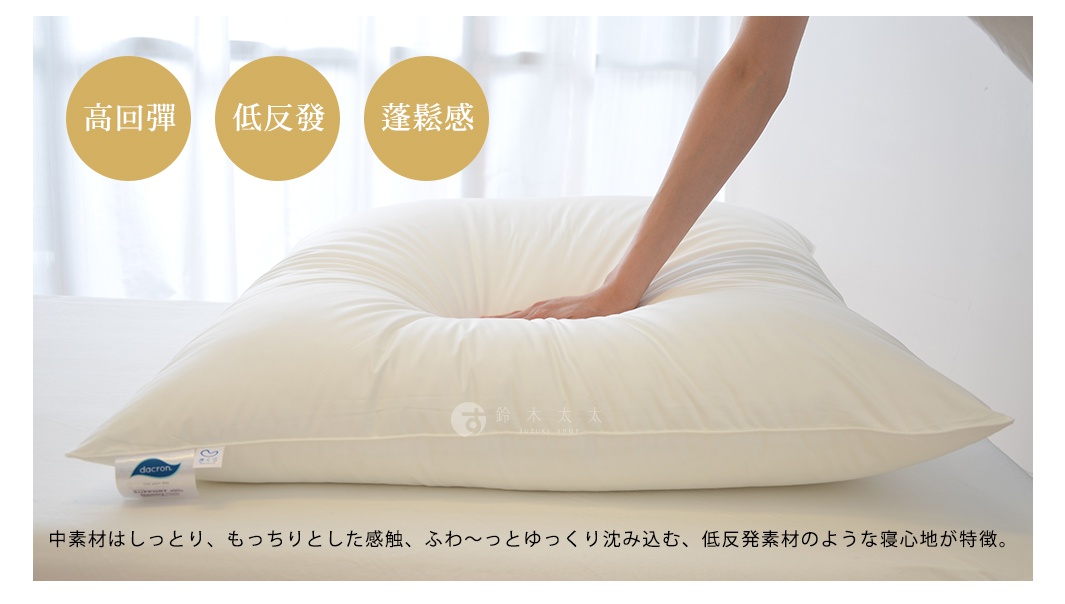 一張米白色枕頭，表面材質光滑，一隻手正按壓枕頭中央，使其形成一個凹陷。枕頭上有品牌標籤。