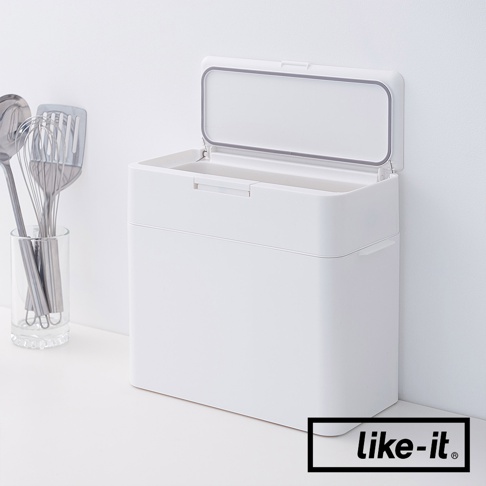 白色塑膠按壓式垃圾桶，容量9.5公升，垃圾桶蓋為透明設計，可向上開啟，側面有掛勾設計，旁邊有一個玻璃杯裝著廚房用具。
