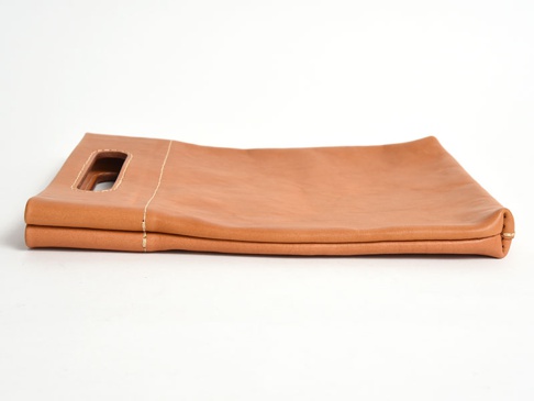 淺棕色皮革製的職人手作直式收納袋中袋，有提把設計，車縫線清晰可見，材質為皮革。