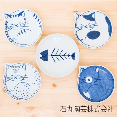 白色陶瓷小碟五入組，設計為可愛的貓咪造型，以藍色線條描繪，其中一只碟子繪有藍色魚骨圖案。