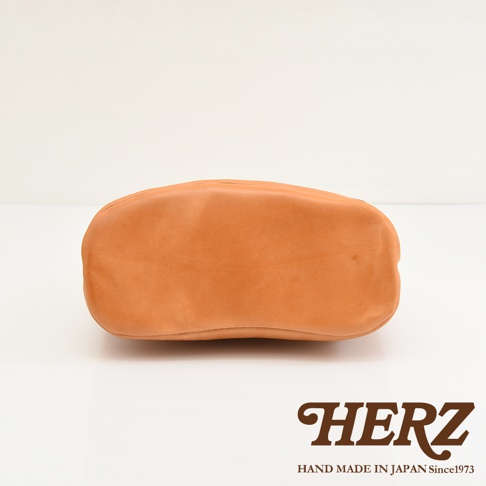 HERZ 品牌標誌及 Handmade in Japan Since 1973 字樣，搭配皮革包的底部視角。