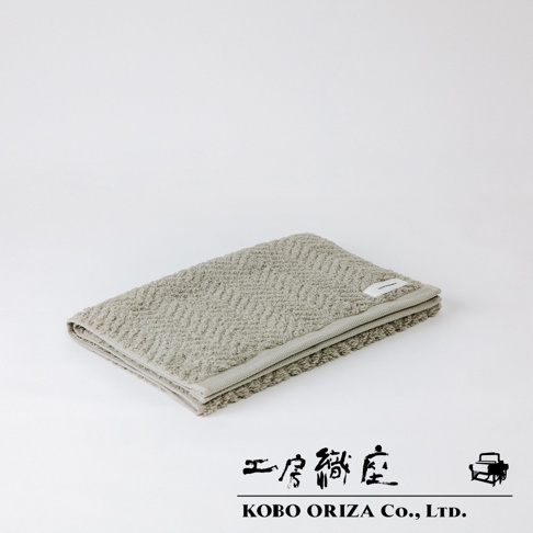 ECOR 天然系人字紋有機棉毛巾，呈淺灰色，織有細緻的人字紋路，材質為有機棉，觸感柔軟。