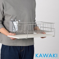 銀色不鏽鋼材質的珪藻土碗盤餐具瀝水架，包含一個餐具收納盒和一個大型瀝水籃，架設於白色珪藻土底盤上，由一人手持展示。