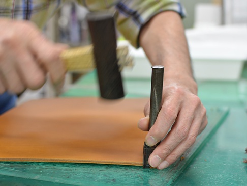 職人手作皮革A5筆記本書套 (KB-4-L) L，黃褐色皮革，使用沖孔工具於綠色切割墊上加工。