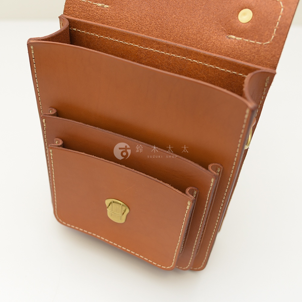 職人手作皮革單肩兩用小方包，採用棕色苯染皮革，車縫線清晰，設有翻蓋及金屬鎖扣，內部有多個隔層。