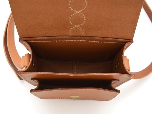 淺棕色皮革單肩包，內部展示，頂部翻蓋開啟，露出主隔層和內部口袋，皮革飾有十字繡紋路。