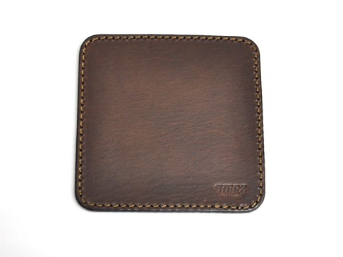 職人手作皮革印章墊板 (KZ-72)，深棕色皮革，表面有細緻紋理，邊緣以黃色線縫合，右下角壓印有「HERZ」和「MADE IN JAPAN」字樣。