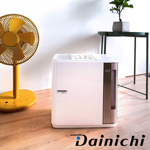 白色方形空氣清淨保濕機，右側有深褐色半透明水箱，頂部有控制面板。左側有一台亮黃色立扇。