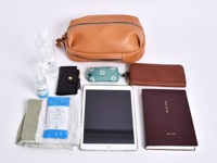 職人手作皮革立體運動斜背包，搭配水瓶、酒精噴霧、黑色錢包、綠色點點收納包、平板電腦、深棕色長夾、深紅色筆記本和毛巾。