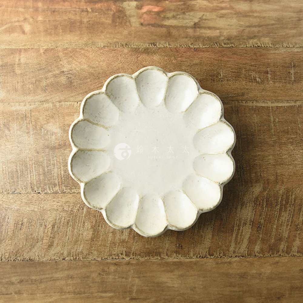 一個21公分、米白色、具有花型紋理的陶製主食盤，盤緣有淡淡的黃褐色邊緣，放置於木紋背景上。