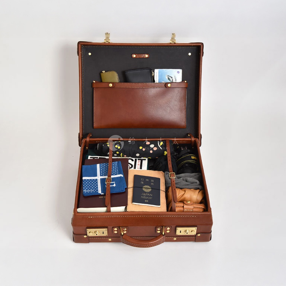 職人手作皮革英倫風便攜手提行李箱，經典棕色，內含多個隔層，裝有護照、筆記本、折疊傘、相機及衣物等旅行用品。