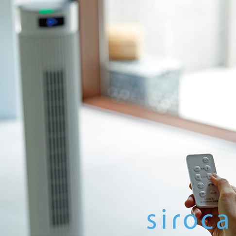 一台淺灰色直立式循環扇，配有遙控器，遙控器上有日文按鈕。