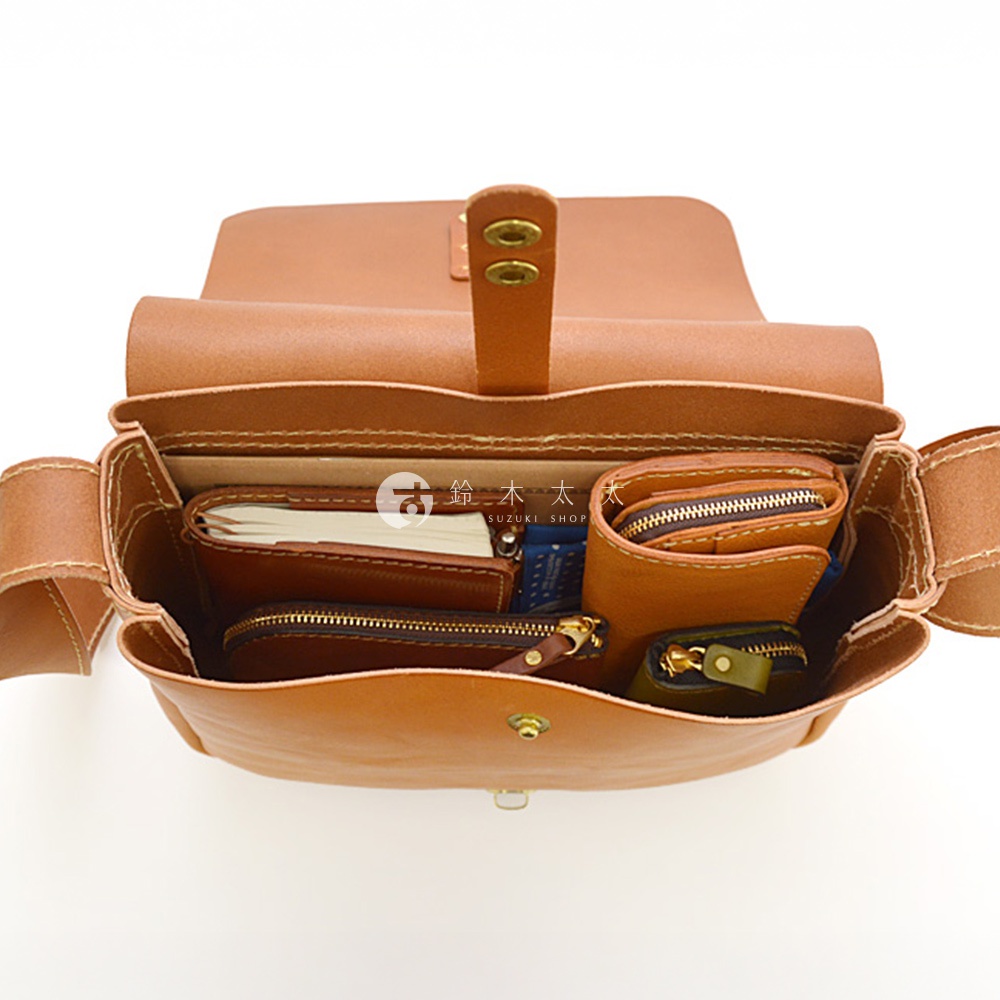 日製HERZ手工皮革軟皮橫式斜背包CK-94，包內展示有筆記本、錢包及零錢包等物品。