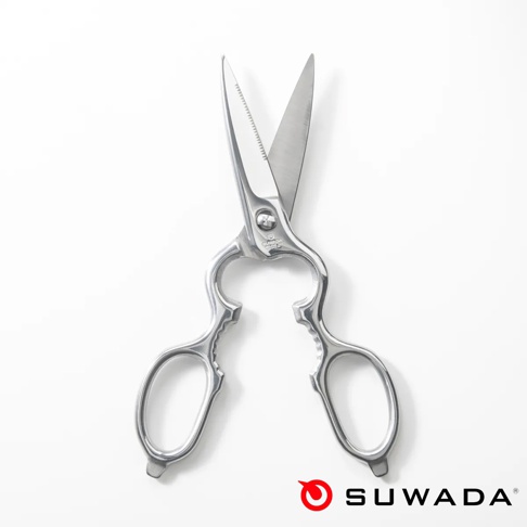 一把銀色金屬製成的 SUWADA 日本職人多功能廚房剪刀，呈現正面俯視視角，剪刀刀刃部分呈張開狀，其中一側刀刃帶有鋸齒設計，手柄處則設計有多功能凹槽結構，整體質感細緻，下方並標有 SUWADA 品牌標誌。