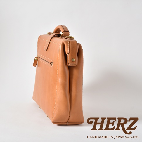 職人手作皮革軟式杜勒斯三用背包BJ-16，呈現自然淺棕色皮革質感，側面有拉鍊暗袋及金屬扣環，頂部設有手提把。