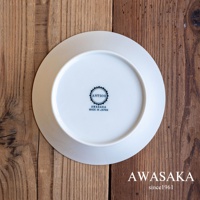 一個白色陶瓷盤，底部印有黑色「ANTICO」、「AWASAKA」及「MADE IN JAPAN」字樣，置於木紋背景上。