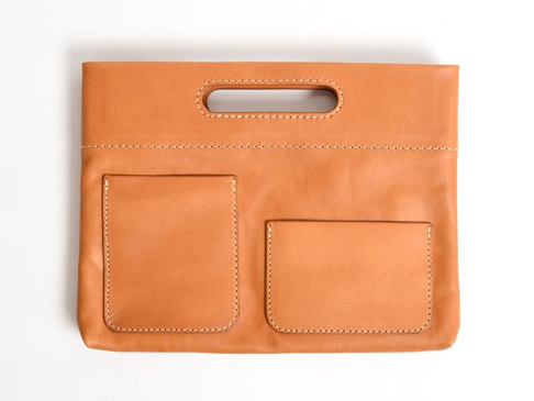 職人手作咖啡色皮革橫式收納袋中袋，具有一個長方形提把，正面有兩個方形的置物口袋，縫線清晰。