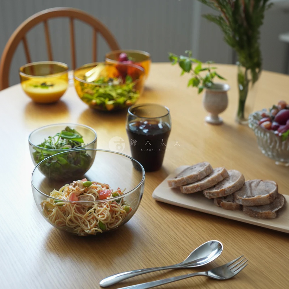 LAGOM 清透復古圓潤點心碗-L，玻璃材質，碗內盛有麵食和蔬菜。桌面上還有其他尺寸的玻璃碗，分別盛有沙拉和黃色液體，以及一杯深色飲品和切片的肉。